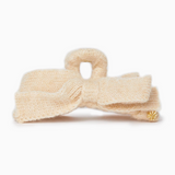 Cream-colored knitted bow headband on a white background