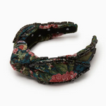 Floral patterned headband with black embellishments on a white background