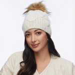 Woman wearing a white knit beanie with a fur pom-pom on a white background