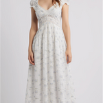 Woman wearing a white floral dress on a plain background