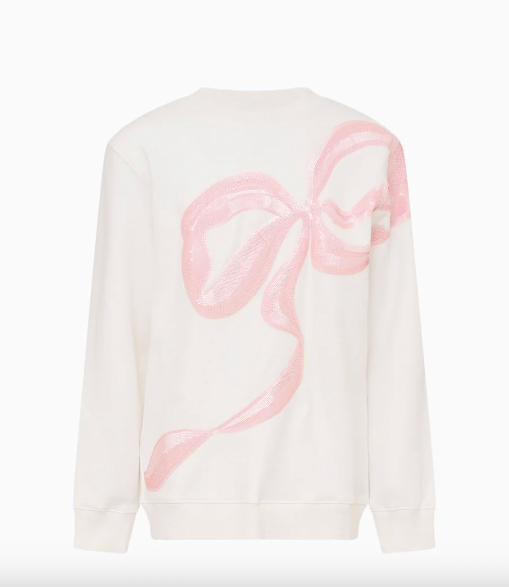White sweater with a pink bow design on a white background