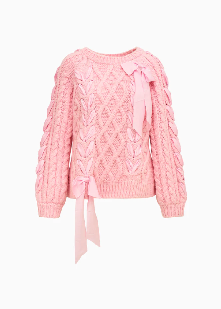 Pink cable knit sweater with a tie detail on a white background