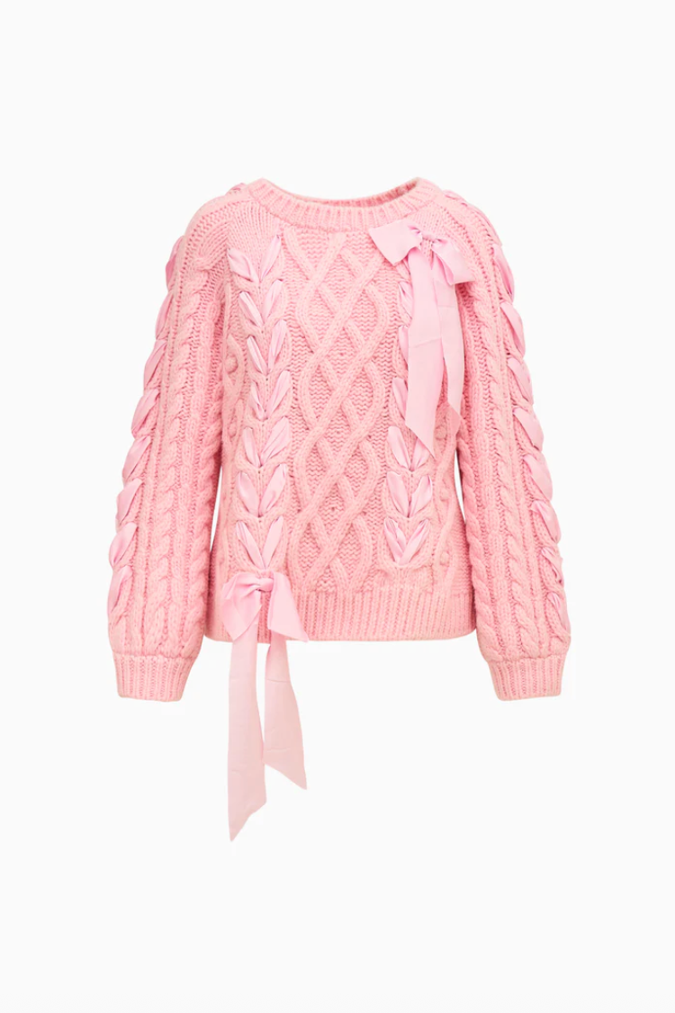 Pink cable knit sweater with a tie detail on a white background