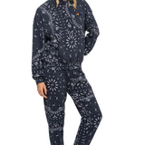 Person wearing a charcoal sweat pants and hoodie with white patterns on a white background 