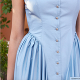 Light blue dress with decorative buttons on a blurred background