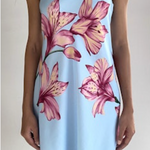 Light blue strapless dress with pink floral pattern worn by a person on a plain background