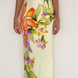 Woman wearing a light yellow slip dress with colorful floral pattern against a white background