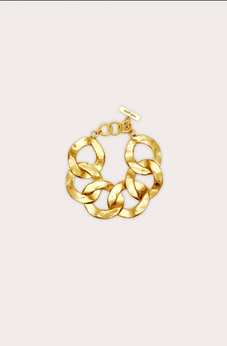 Gold chain bracelet on a light beige background