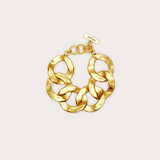 Gold chain bracelet on a light beige background