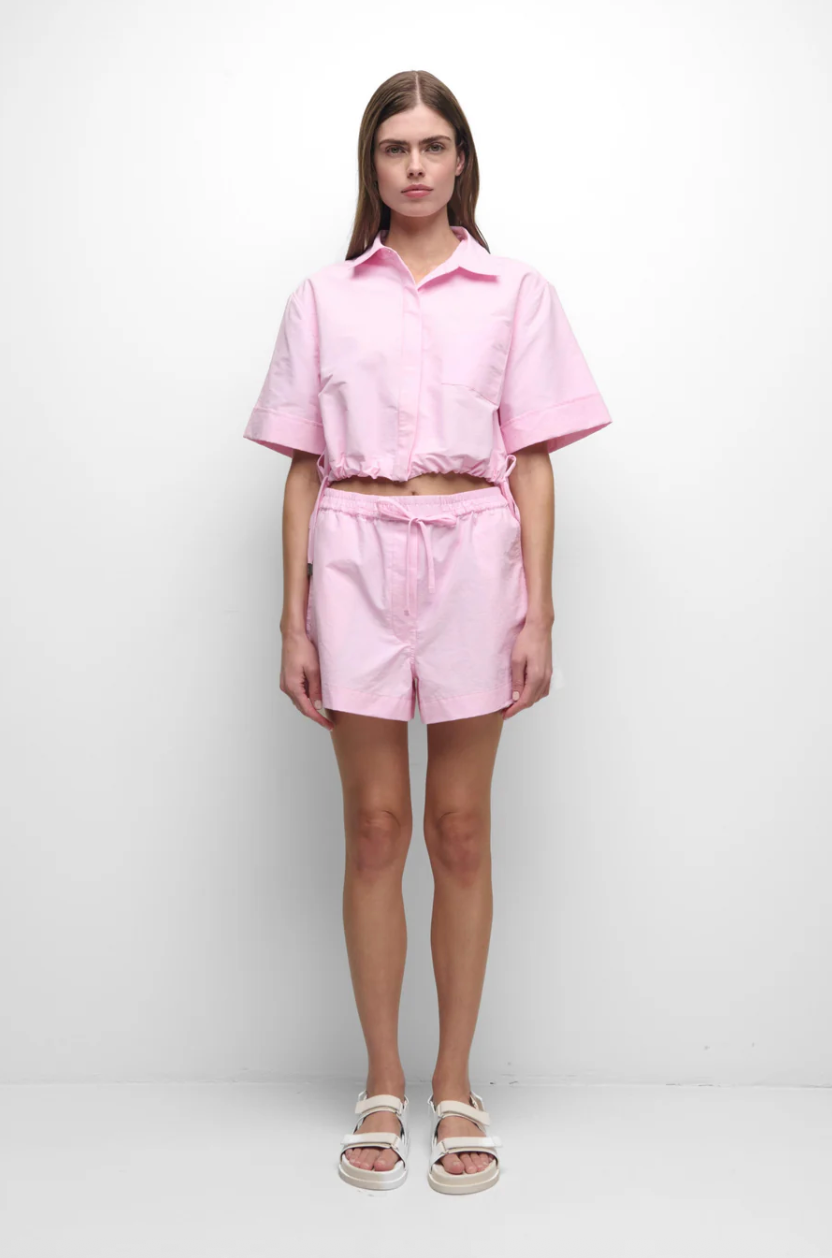 Person wearing a pink outfit on a white background