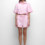 Person wearing a pink outfit on a white background