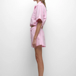 Woman wearing a pink outfit with a white background