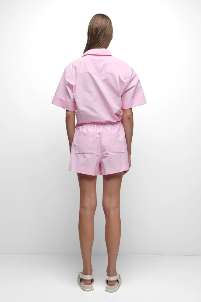 Person wearing a pink outfit on a white background