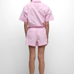 Person wearing a pink outfit on a white background