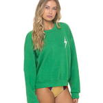 Woman wearing a green sweatshirt with a white logo on a white background