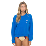 Woman wearing a blue sweatshirt with a white lightning bolt design on a white background