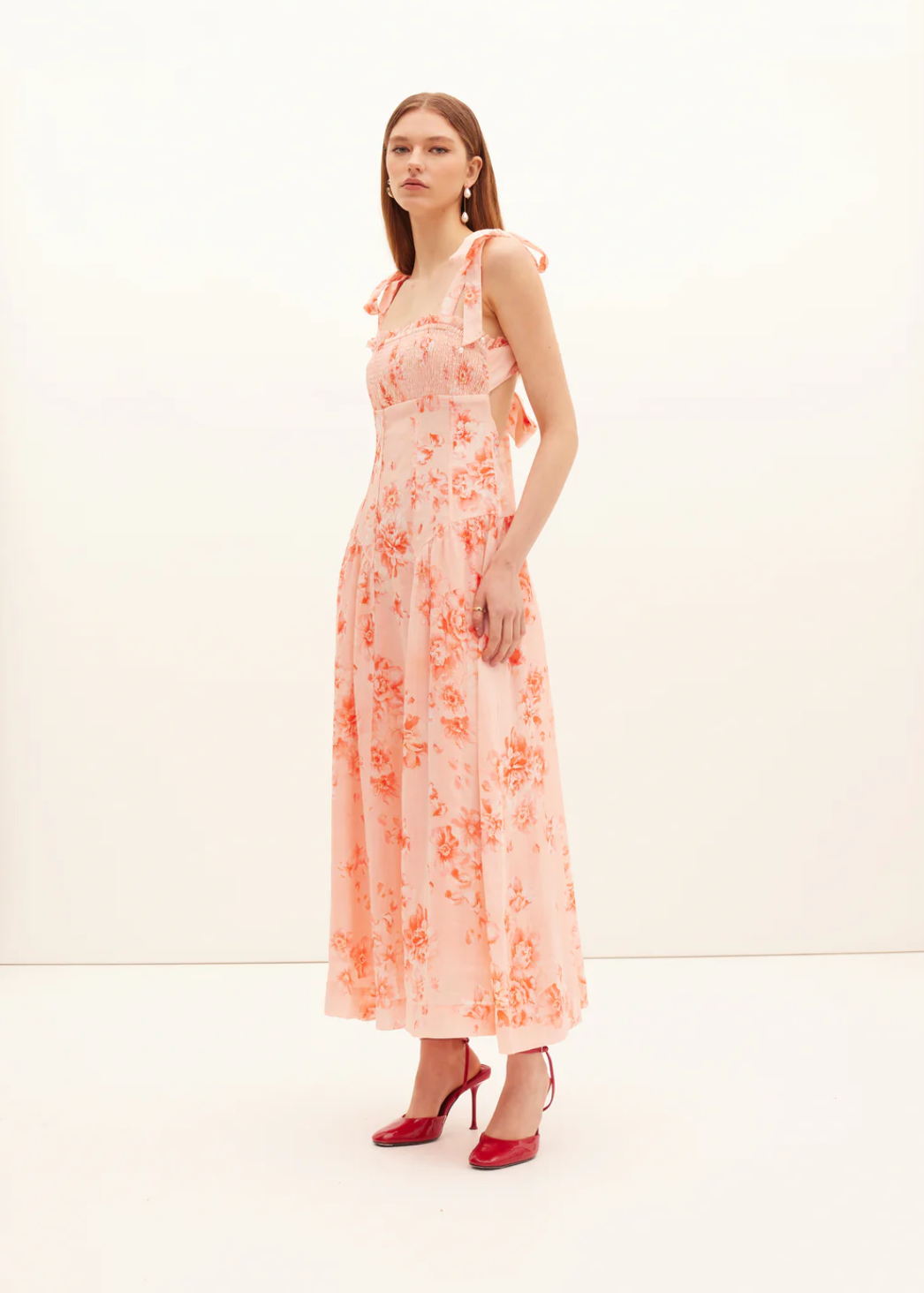 Woman wearing a floral dress with a plain background