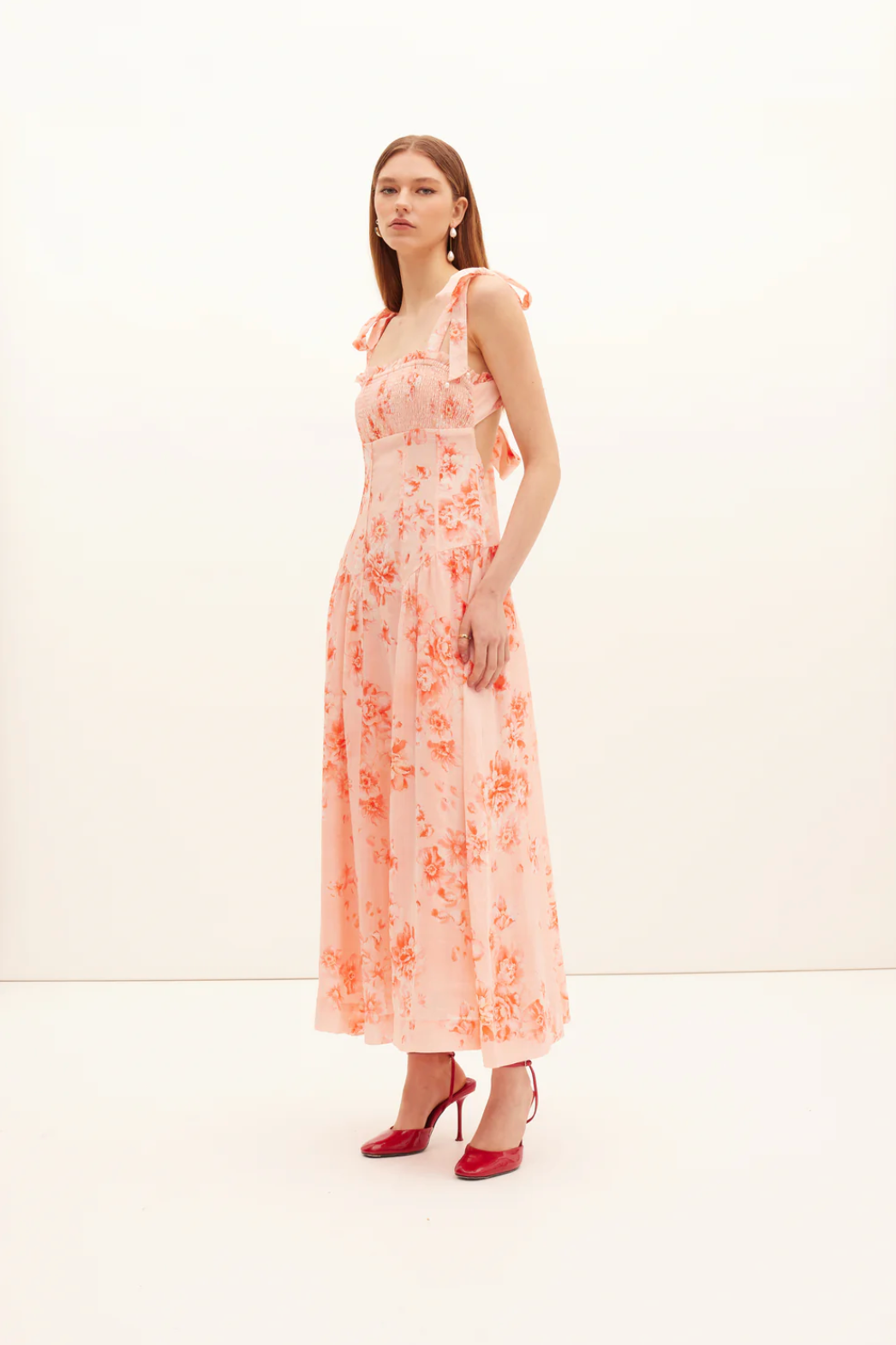 Woman wearing a floral dress with a plain background