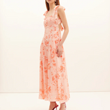 Woman wearing a floral dress with a plain background