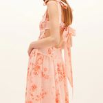 Woman wearing a floral dress with a plain background