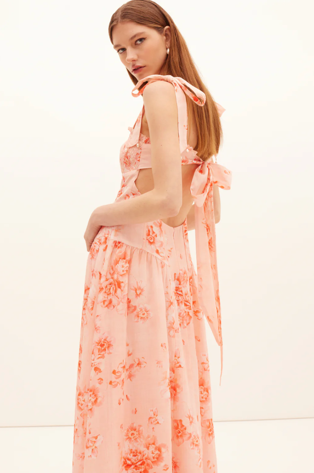 Woman wearing a floral dress with a plain background