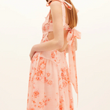 Woman wearing a floral dress with a plain background