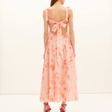 Woman wearing a pink floral dress with a white background