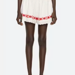 White outfit with red floral embroidery on a white background