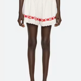White outfit with red floral embroidery on a white background