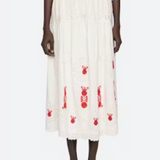 Person wearing a white dress with red patterns on a white background