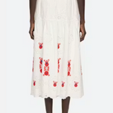 White skirt with red patterns worn by a model on a white background