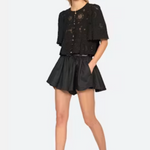 Woman wearing a black outfit with a top and shorts on a white background