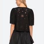 Black outfit with intricate designs on a plain background