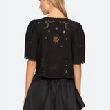 Black outfit with intricate designs on a plain background