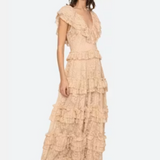 Woman wearing a beige ruffled dress on a white background