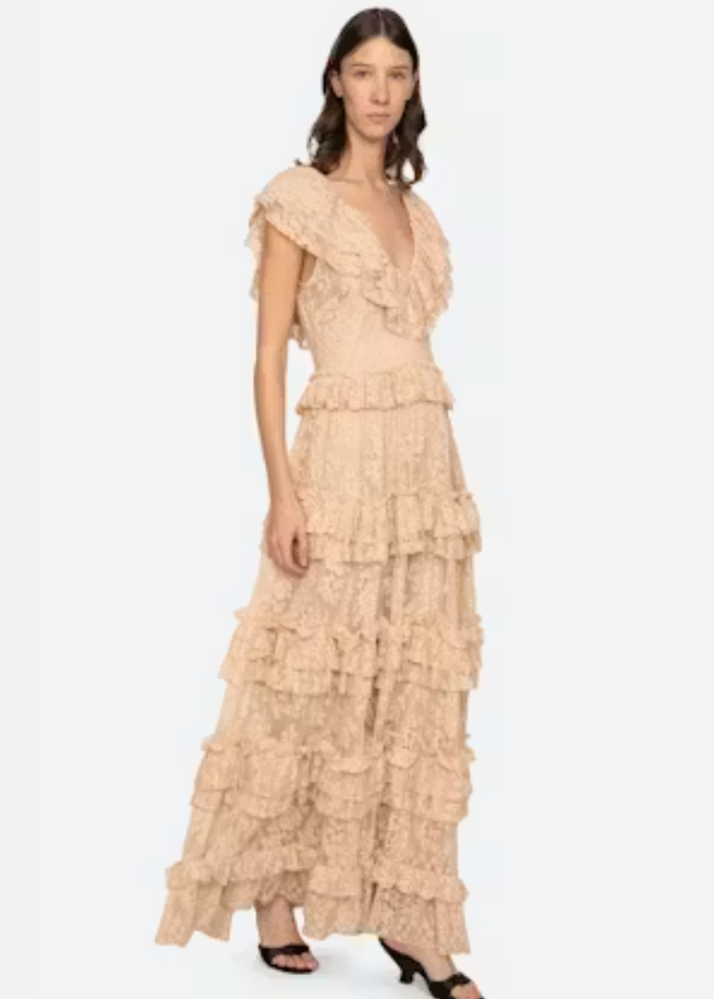 Woman wearing a beige ruffled dress on a white background
