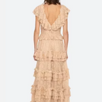 Woman wearing a beige ruffled dress on a white background