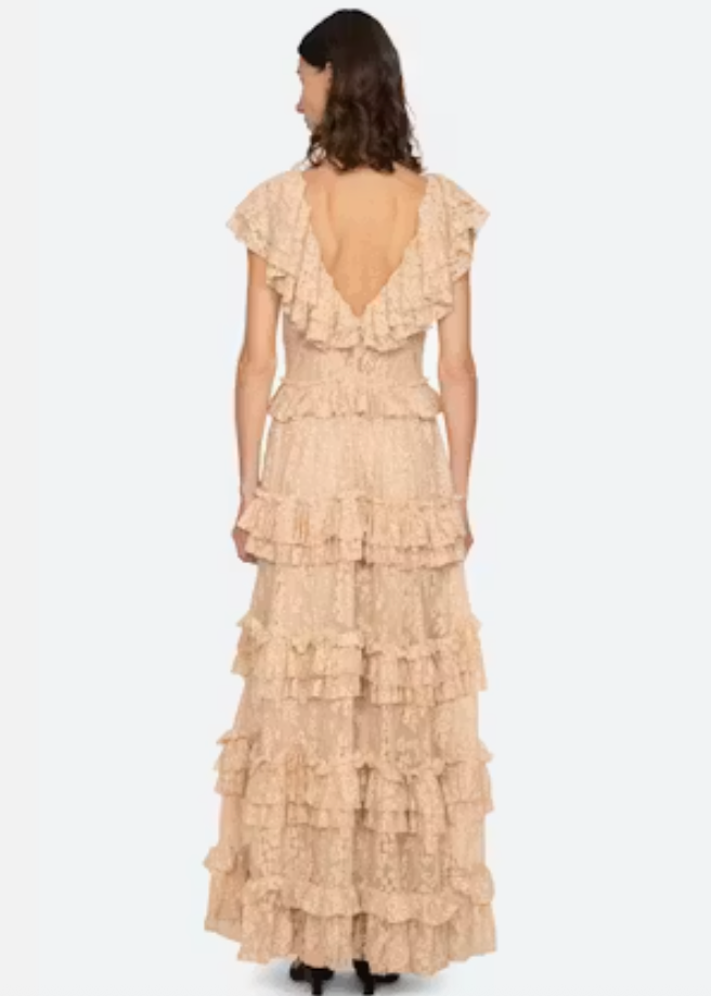 Woman wearing a beige ruffled dress on a white background