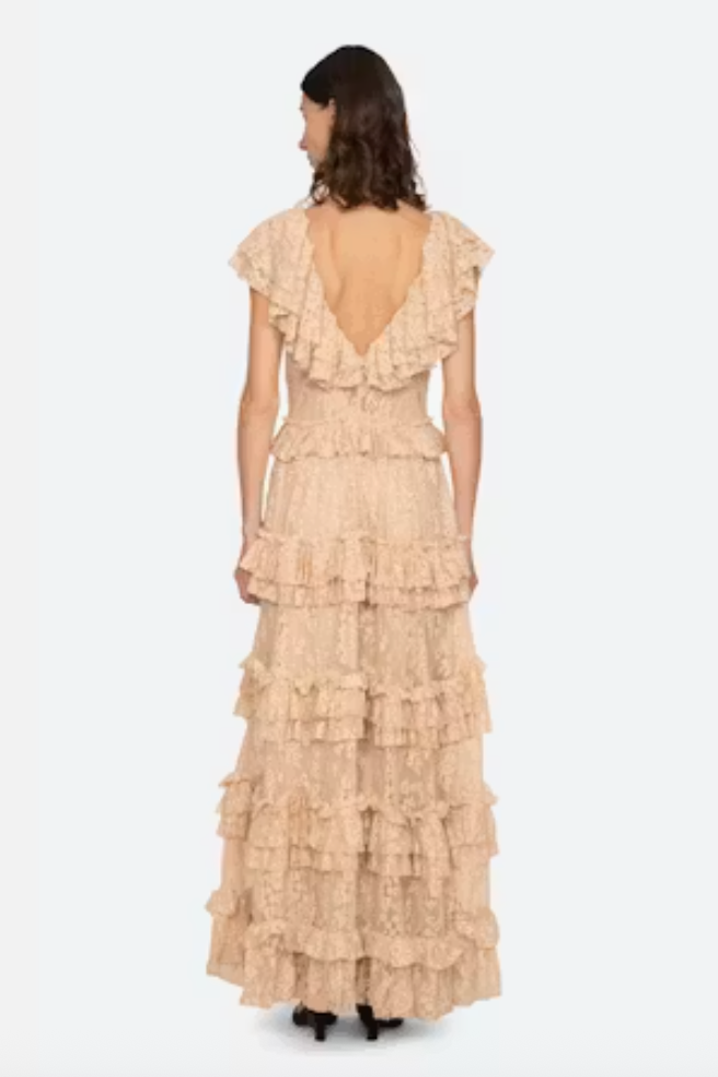 Woman wearing a beige ruffled dress on a white background