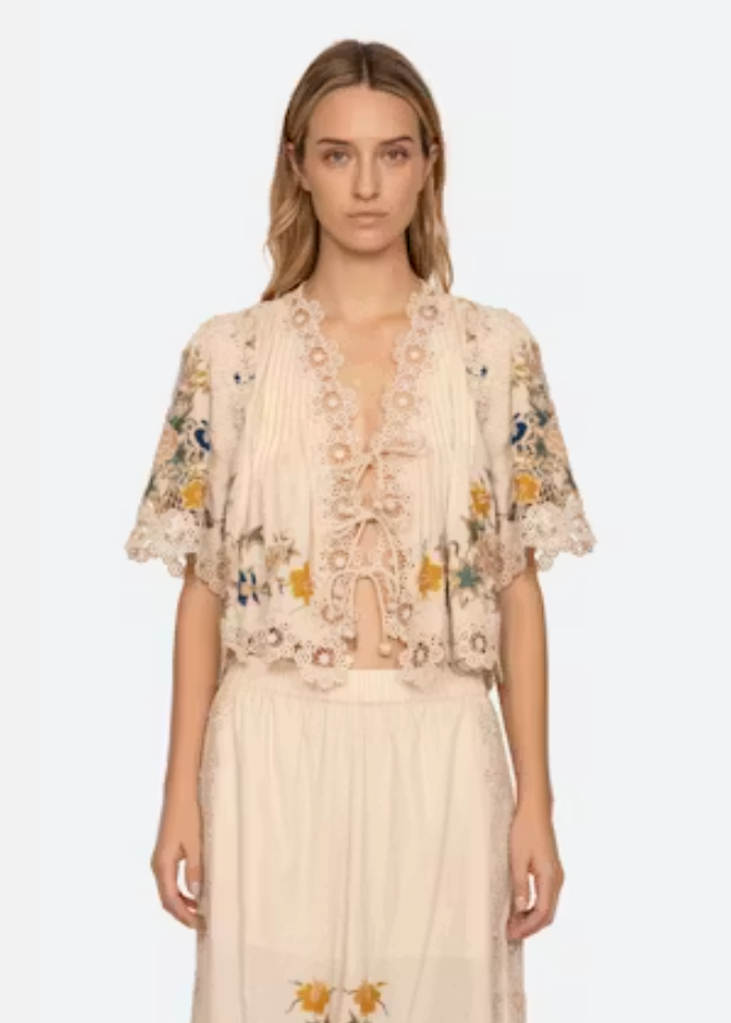 Woman wearing a floral embroidered dress on a white background
