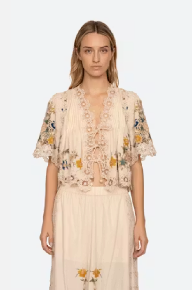 Woman wearing a floral embroidered dress on a white background