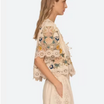 Woman wearing a floral embroidered top and skirt on a white background