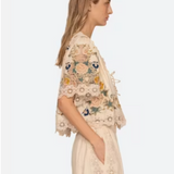 Woman wearing a floral embroidered top and skirt on a white background
