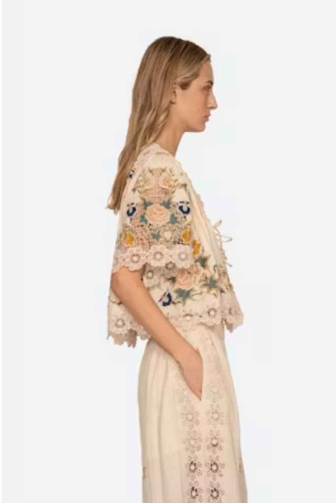 Woman wearing a floral embroidered top and skirt on a white background