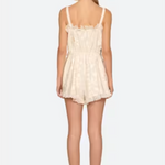 Woman wearing a cream lace dress on a white background
