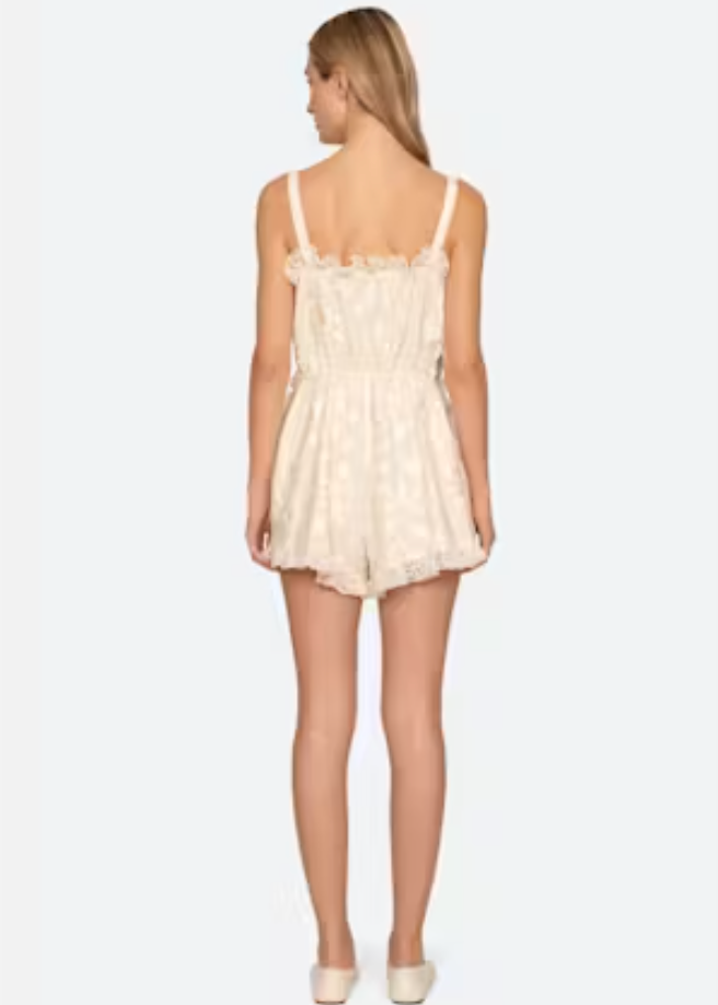 Woman wearing a cream lace dress on a white background