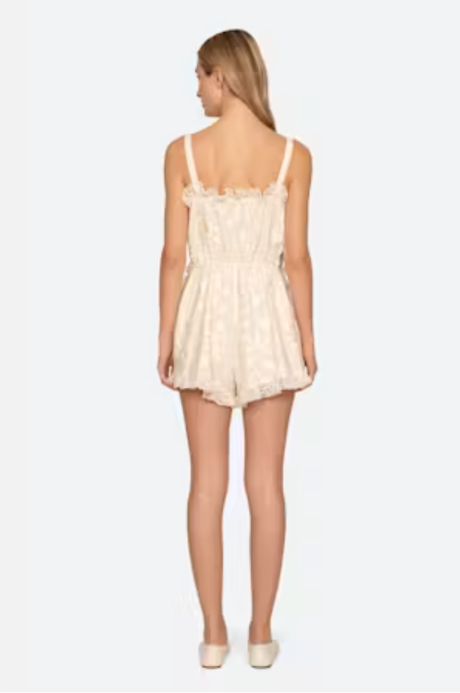 Woman wearing a cream lace dress on a white background