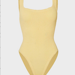 Yellow ribbed swimsuit on a light gray background