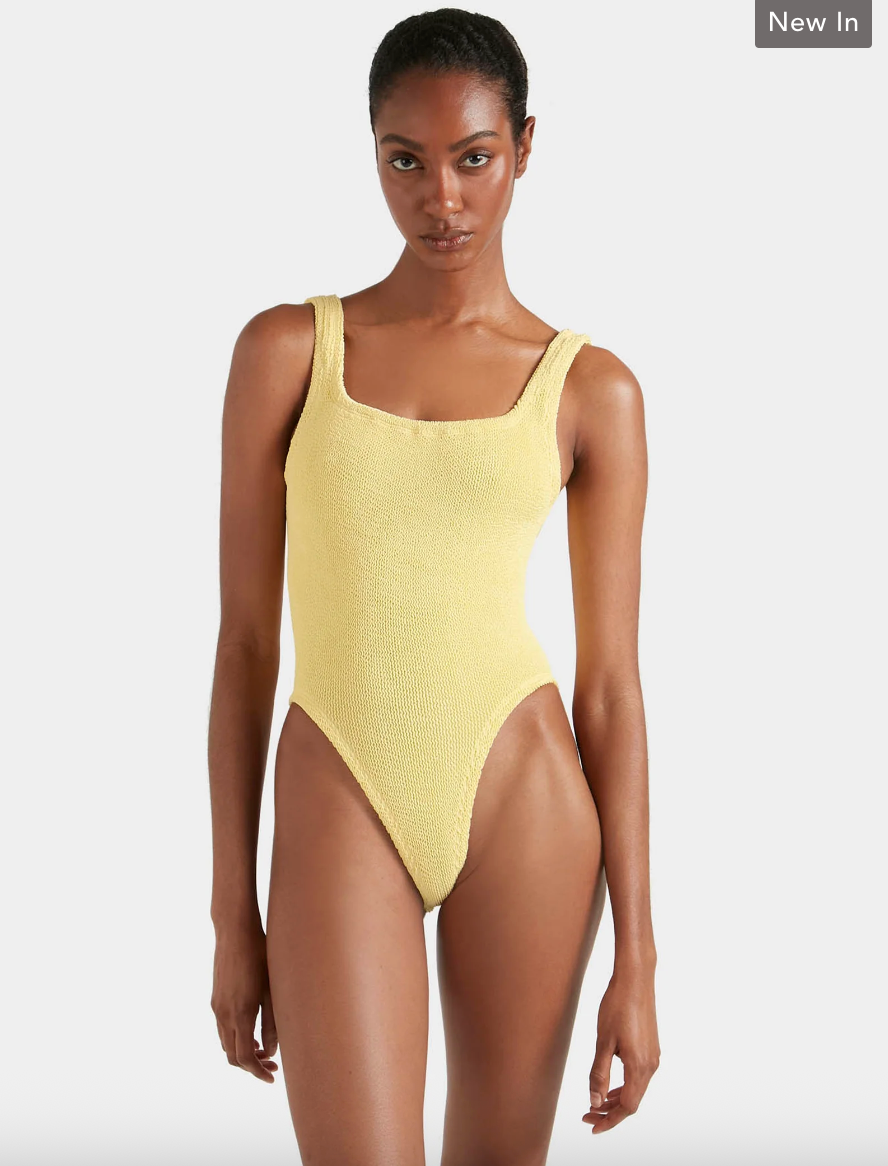 Woman wearing a yellow swimsuit on a white background