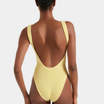 Yellow swimsuit with open back worn by a model on a white background
